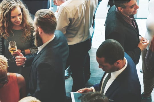 a crowd of corporate employees network at an event