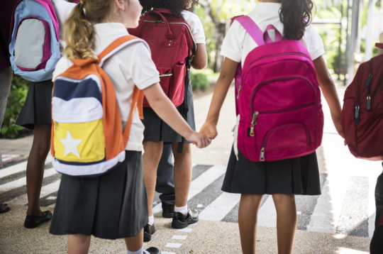 a group of students hold hands on a field trip